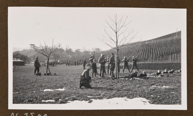 Soldaten mit Gewehren vor Weinberg