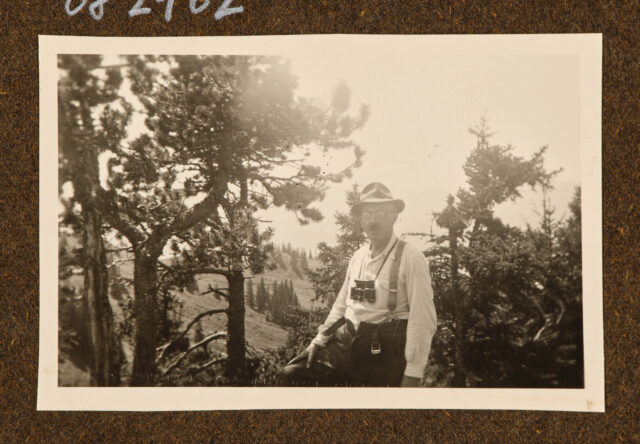 Meinrad Inglin mit Feldstecher vor Bäumen