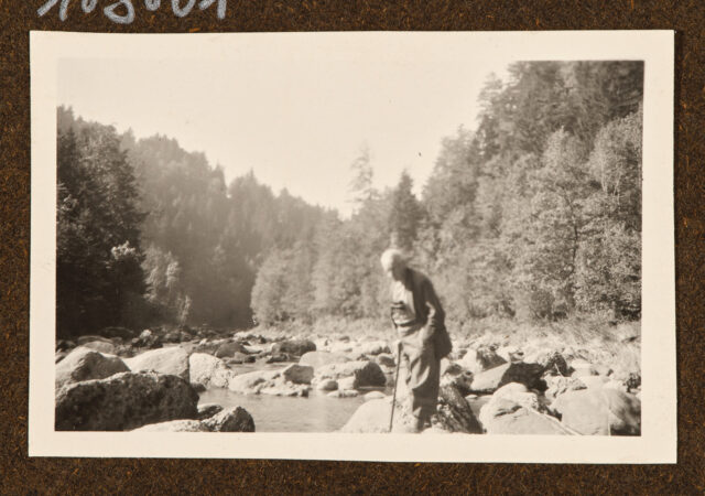 Meinrad Inglin (?) auf Steinen am Fluss