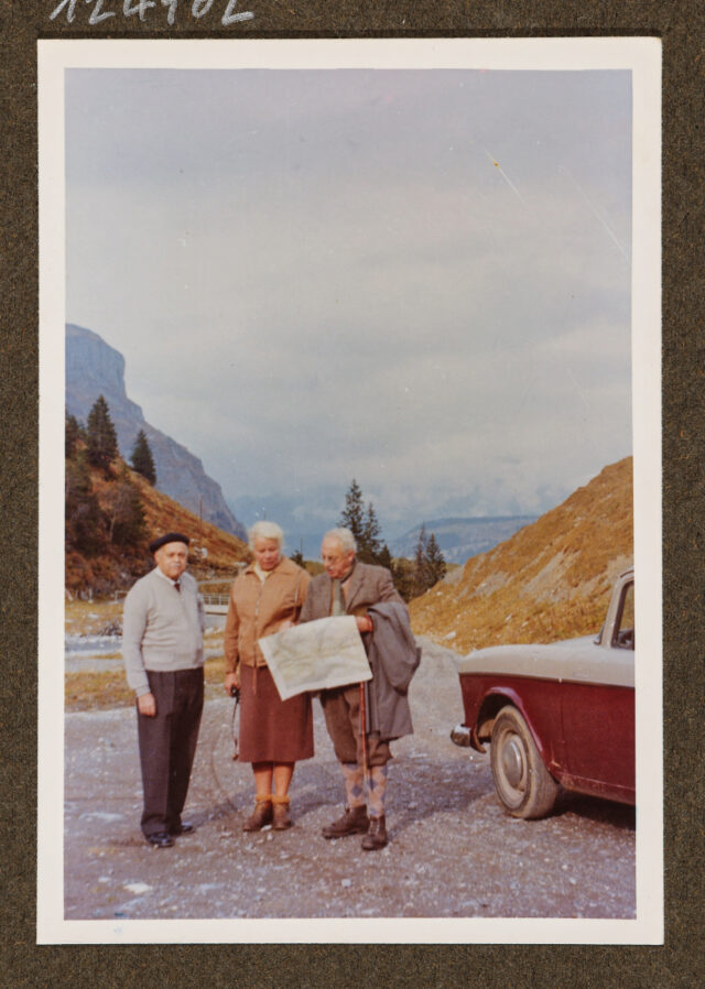 Gottfried Stiefel, Bettina Zweifel und Meinrad Inglin neben einem Auto vor Bergpanorama