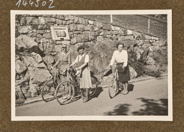 Drei Radfahrerinnen vor Mauer
