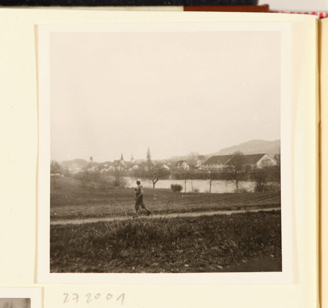 Meinrad Inglin (klein) vor Fluss und Dorf