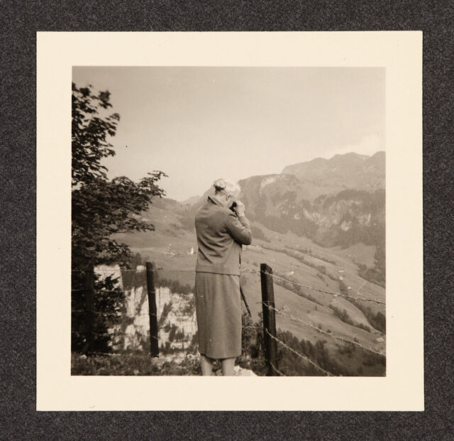 Bettina Zweifel (Rückenansicht) mit Feldstecher vor Panorama