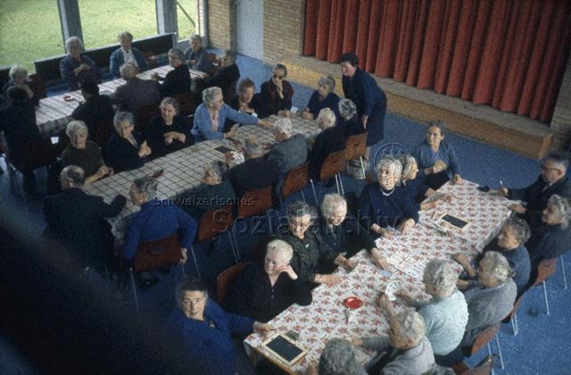 "Freizeitanlage, Altersnachmittag" - ältere Männer und Frauen beim Kartenspielen; um 1980