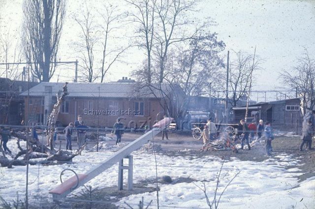 Spielplatz "Zofingen" - spielende Kinder, Feuer, Wippe, Kletterbaum; um 1970
