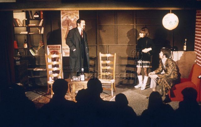 Theater - "Zwei Männer und eine Frau bei einer Aufführung"; um 1975