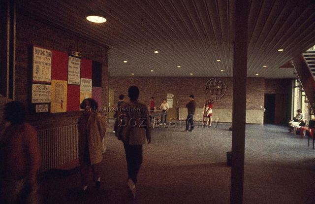 "Europäische Länder: Centre éducatif et culturel, Verres France" - Eingangsraum mit Teppichboden, Informationstafel, Jugendliche spielen Tischtennis; um 1970