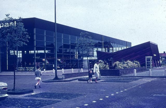 "Europäische Länder: Kulturzentrum De meer paal, Dronten Holland" - Aussenansicht auf das Haus mit Flachdach, grossen Fensterfronten und einem hölzernen Anbau, im Vordergrund sieht man einen gepflasterten Platz; um 1970