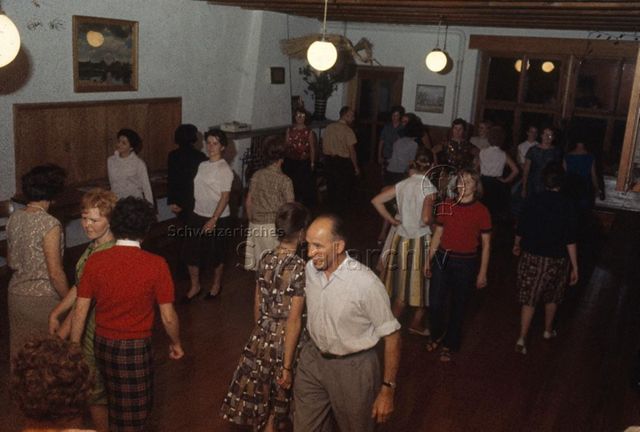 "Spiel- und Sportleiter; Spielwochen und -Kurse: Tänze Spielwoche Herzberg" - Frauen und Männer gehen im Raum hin und her; um 1970