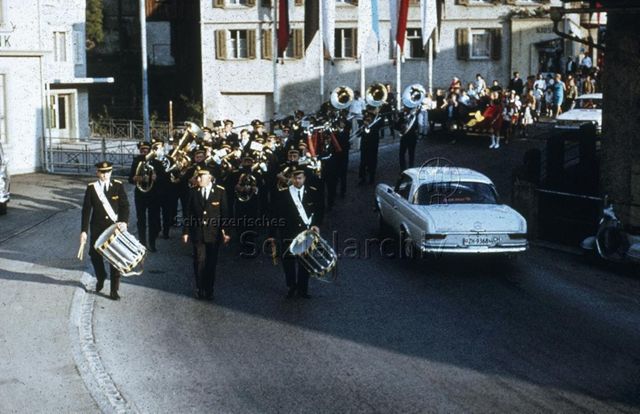 "Siedlungs- und Quartierspielplätze: Lichtensteig SG" - Strassenumzug, man sieht die Stadtmusik in schwarzen Uniformen; um 1970