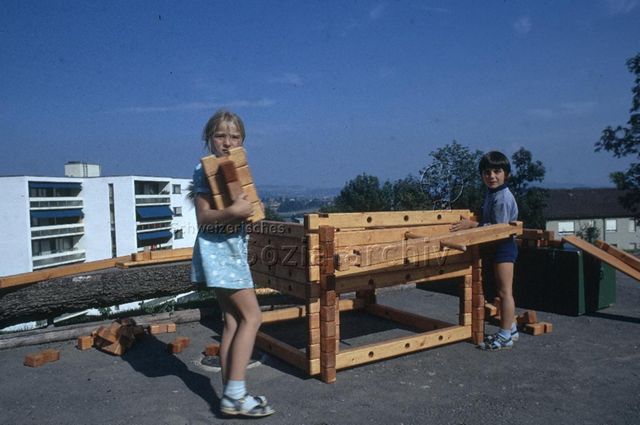 "Spielplatz Adliswil" - Zwei Kinder beim Bauen einer Hütte aus Bauelementen; 1971