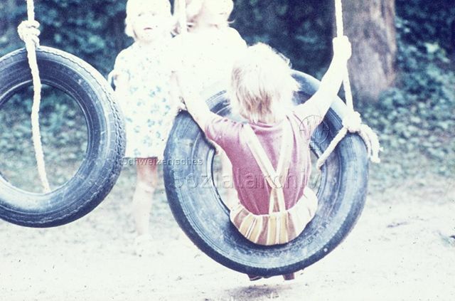 "Robinsonspielplatz Olten" - Kind beim Schaukeln in altem Autoreifen; 1975