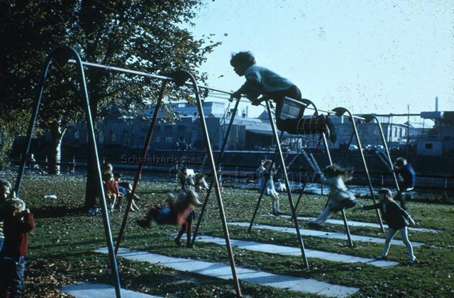 Spielplatz am Fluss - Kinder beim Schaukeln; um 1975
