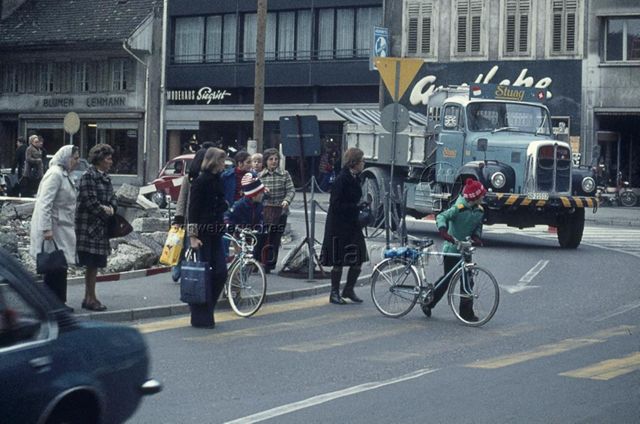 "Fussgängerzone Olten" - Personen überqueren auf einem Zebrastreifen die Strasse; um 1975