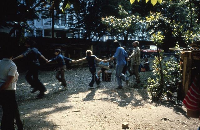"Robinsonspielplatz 'Le Lignon', Genf" - Kinder und Erwachsene bei einem Spiel; um 1975