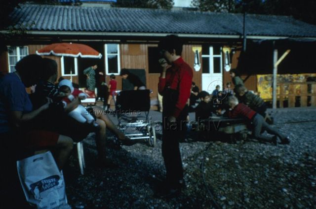 "Robinsonspielplatz Volta, Basel" - Kinder und Eltern bei der Zwischenverpflegung; um 1975