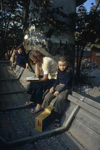 "Robinsonspielplatz Volta, Basel" - Mutter und Mädchen sitzen in einem als Spielgerät dienendem Boot; um 1970
