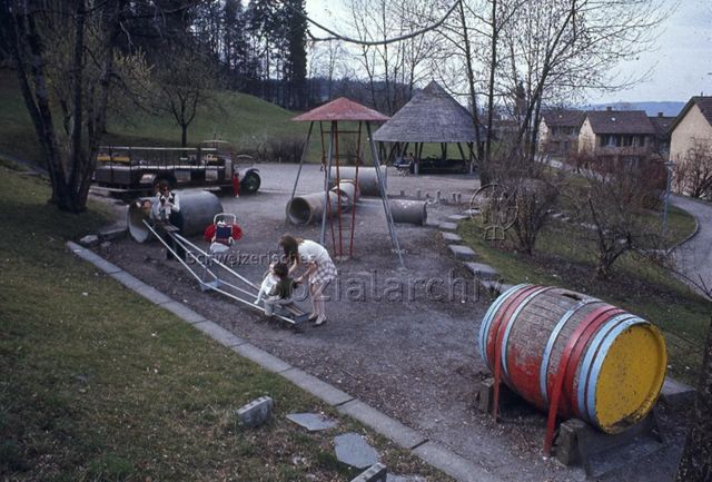 "Spielplatz Siedlung Sonnengarten", Zürich - Kinder und Mütter beim Spielen auf der Wippe; um 1980