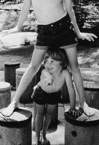 Bosco della Bella, Feriendorf für kinderreiche Familien - Zwei Kinder beim Spielen, ein Kind steht auf zwei Betonsockeln, ein weiteres steht zwischen den Sockeln und zeigt auf Kamera; um 1975