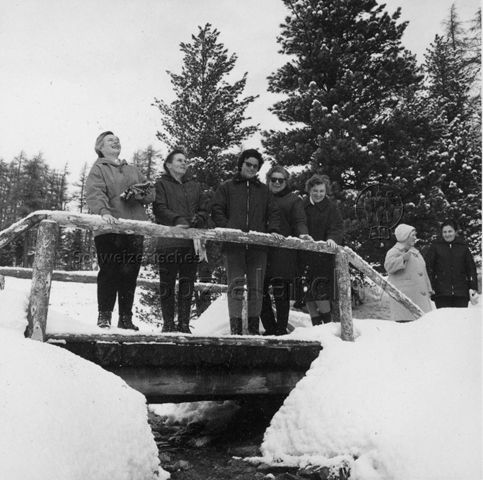 Mütterferien im "Chesa Spuondas" St. Moritz - Spaziergang im Schnee, fünf Frauen stehen auf Brücke; um 1960