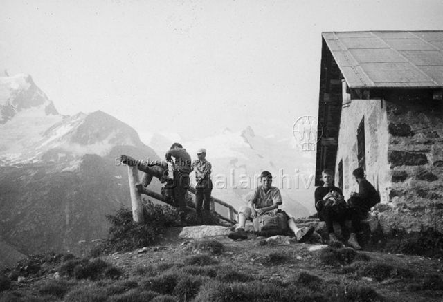 Schulreise Rosegtal Graubünden - Jungen bei einer Berghütte, im Hintergrund Bergmassiv; um 1965