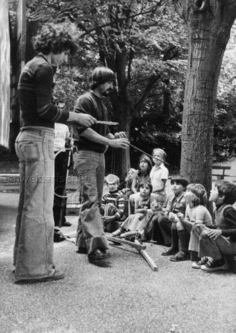 "Spielwaage Basel, Alte Kinderspiele" - Leiter zeigen Kindern Diabolo (Spielgerät); 1975