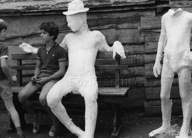 "Robi Olten" - Junge sitzt mit Gipsfigur auf Bank; 1976