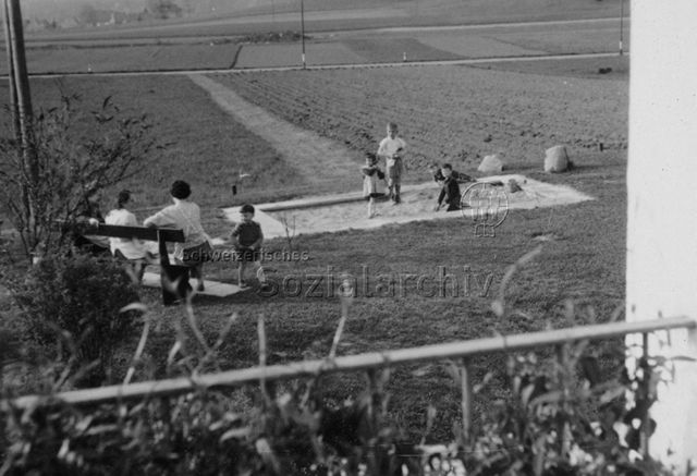 Sandspielplatz in Wohngegend, spielende Kinder; um 1970