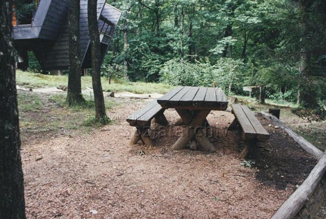Bosco della Bella, Feriendorf für kinderreiche Familien - Tisch und Bänke, hinten links ein Ferienhaus; 1997