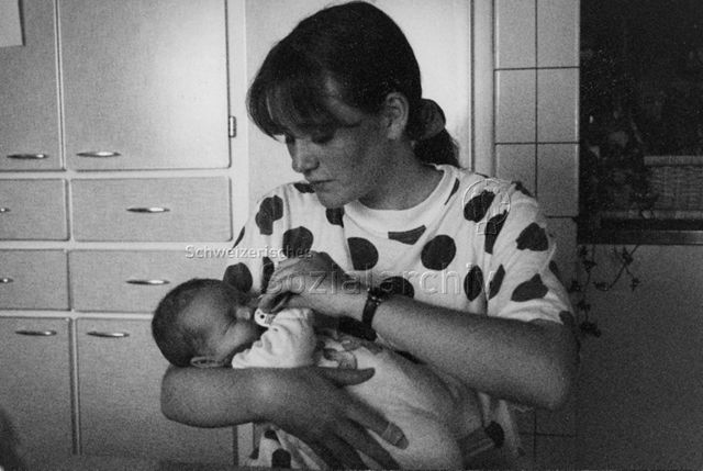 PraktikantInnenhilfe: Einsätze - Praktikantin mit Säugling in den Armen; 1998