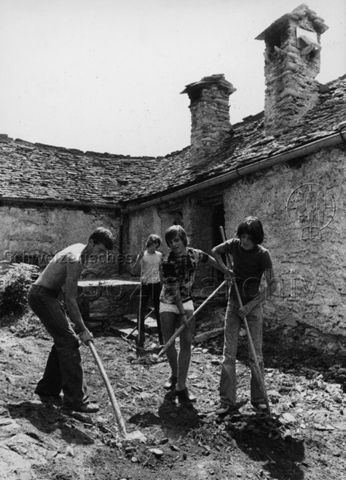 "Jugendliche im sozialen Einsatz: Haussanierung im Onsernone-Tal" - Jugendliche bei der Arbeit mit Schaufeln; 1976