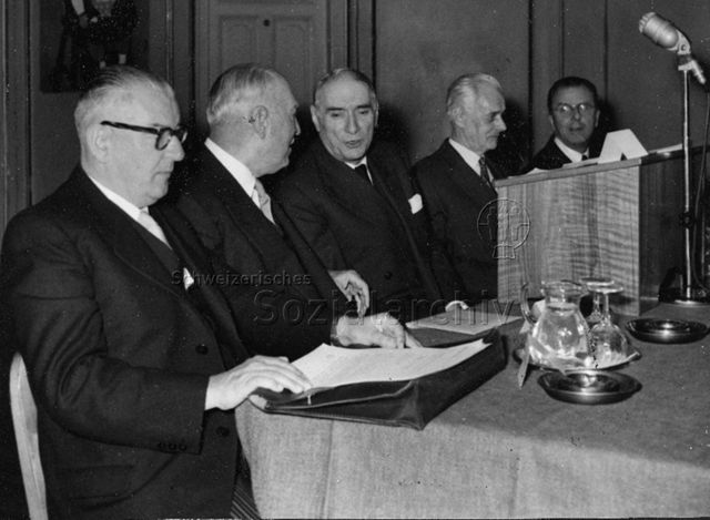 Gesamtschweizerische Mitarbeitertagung - Fünf Männer, darunter Ulrich Wille (2.v.l.), Stiftungskommissionspräsident, auf dem Podium; 1957