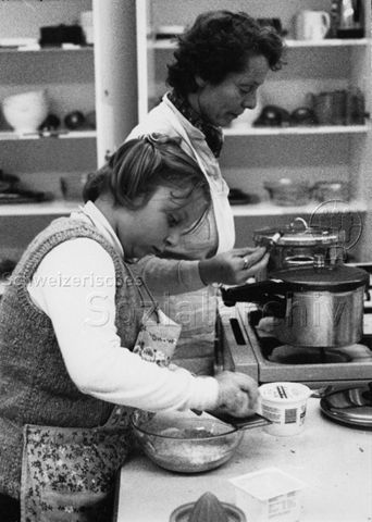 "Kochkurs für übergewichtige Kinder, Schularzt aus Bern" - Frau und Mädchen beim Kochen; um 1980