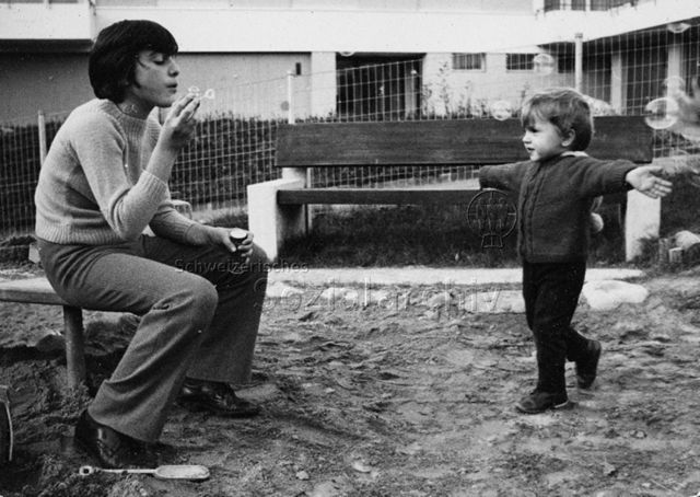 "Freizeitanlagen Schweiz", Siedlungsspielplatz Lichtensteig - Jugendlicher und Kind beim Seifenblasen pusten; 1970