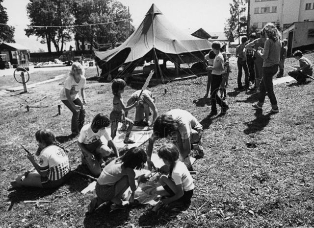 Kinder bereiten Schlangenbrot vor, vermutlich in einem Zeltlager, um 1975