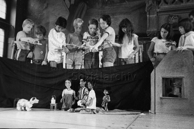 Kinder beim Aufführen eines Marionettentheaters; um 1985