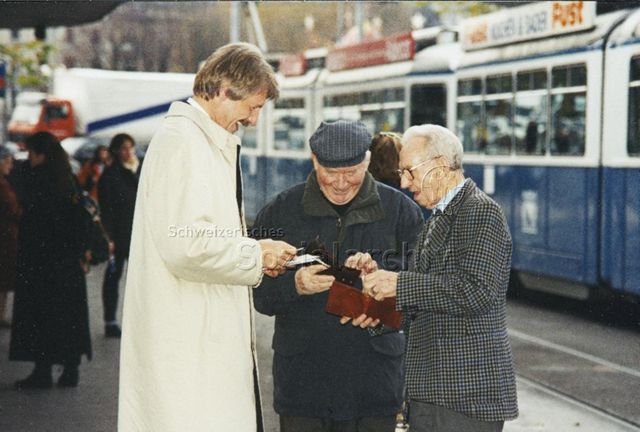 "Markenverkauf am Bellevue mit Zürcher Stadtpräsident Josef Estermann" - Herr Estermann beim Verkauf an zwei ältere Herren; 1997
