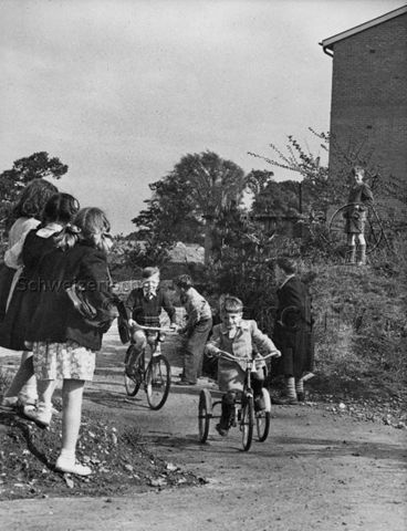 "Harlow Development Corporation, Childrens' playgroud, Glebelands, England" - spielende Kinder, Dreirad, Fahrrad; um 1955