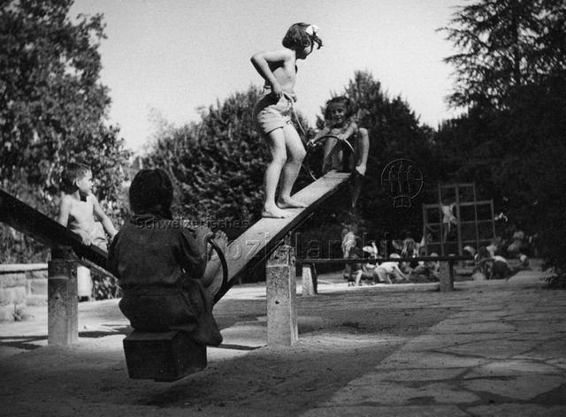 "Kinderspielplatz im Margarethenpark in Basel, die obere Terrasse mit den Spielgeräten" - spielende Kinder auf der Wippe; um 1965