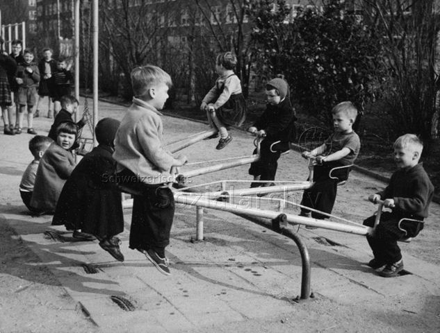 "Kinder auf Wippen in Spielplatz" in den Niederlanden (?); um 1960