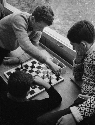 "Freizeitbeschäftigung innen" - Drei Jungen spielen Schach; um 1970