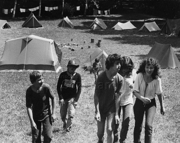 "Abenteuerlager Oberstammheim" - Jugendliche laufen über das Gelände, im Hintergrund stehen Zelte; um 1980