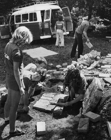 "Abenteuerlager Oberstammheim" - Vorne sind Jugendliche beim Verlegen von Steinen, hinten wird ein Bus entladen; um 1980