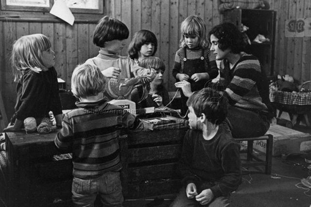 "Kindergarten, Zürich" - Kinder und Kindergärtnerin beim Basteln; um 1970