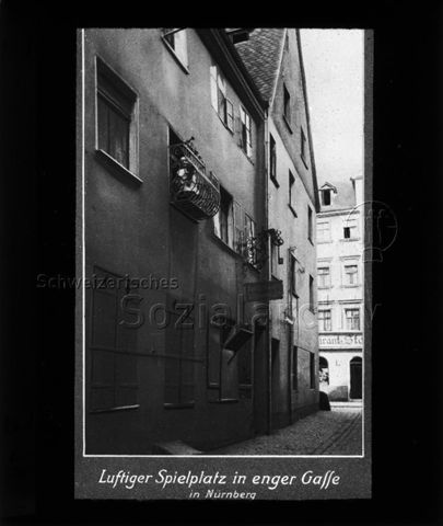 Diaserie zum Thema Säuglingspflege; "Luftiger Spielplatz in enger Gasse in Nürnberg"; Kleinkind auf einem Balkon stehend; um 1930