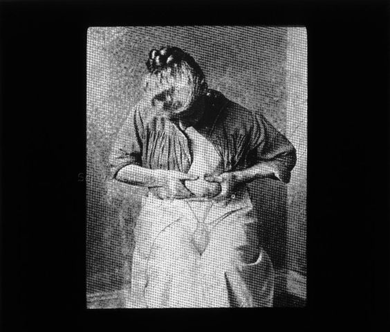 Diaserie zum Thema Säuglingspflege; eine Frau am Milch aus ihrer Brust in eine Milchpumpe drückend; um 1930