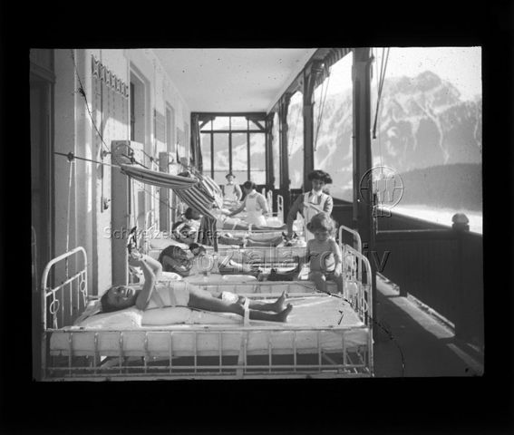 Diaserie zum Thema Tuberkulose; Kinder liegen im Streckverband in Betten auf einem Balkon; im Hintergrund Bergkulisse; um 1930