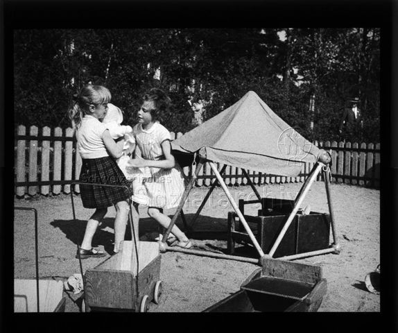 Diaserie zu Spielplätzen; "Stockholm - Kleinkindergitter" - zwei Mädchen halten Kleinkind; um 1960