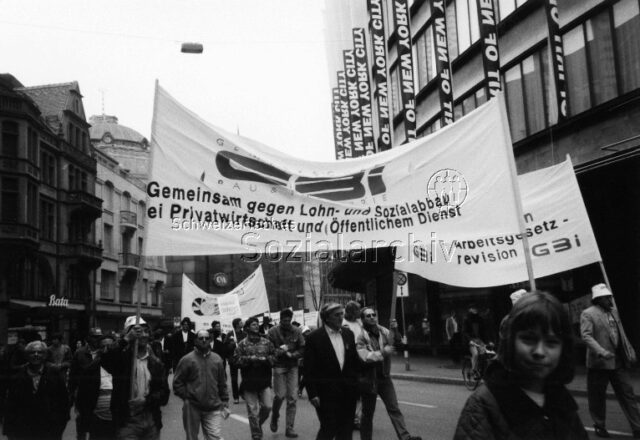 1. Mai-Umzug 1996, Zürich: "Gemeinsam gegen Lohn- und Sozialabbau bei Privatwirtschaft und Öffentlichem Dienst" - Demonstrierende mit GBI-Fahne