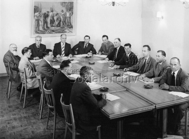 Funktionäre im Kollektiv - Männer um einen Tisch sitzend